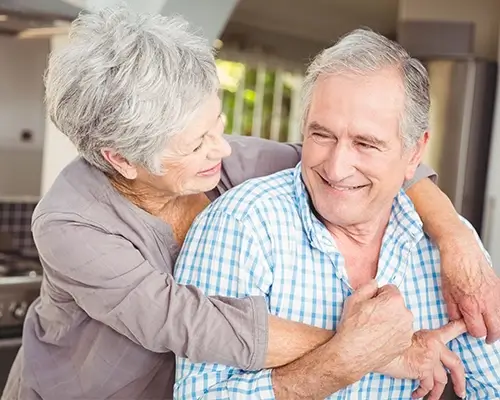  Smiling senior couple embracing at home representing Medi-Cal Regulation Specialists helping older adults with long-term care planning