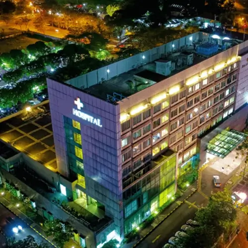 Aerial view of modern hospital at night representing Medi-Cal Regulation Specialists offering medical contracting services to healthcare facilities
