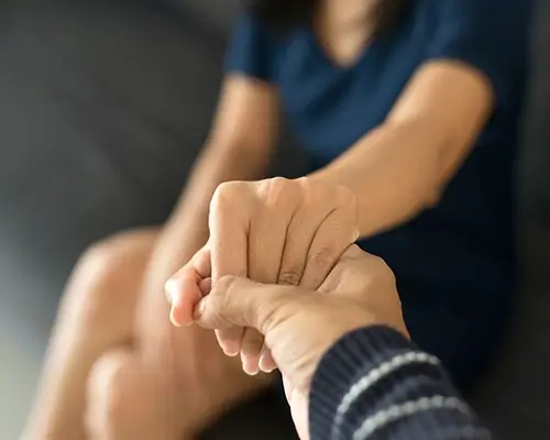 Close-up of supportive hand-holding symbolizing Medi-Cal Regulation Specialists offering compassionate guidance through difficult times