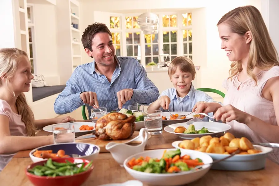 Smiling family enjoying a healthy meal together at home, representing Medi-Cal services for non-seniors, including healthcare coverage, preventive care, and financial assistance for individuals and families in California.