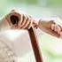 Close-up of elderly hands resting on a wooden cane representing Medi-Cal Regulation Specialists supporting seniors with long-term care and eligibility services